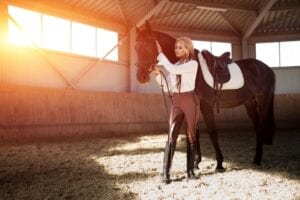 Rider with horse in golden barn light